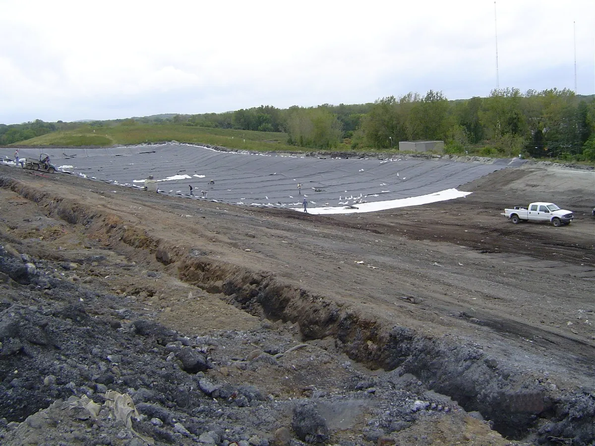 Liner dasar geomembran terpasang di sel landfill yang digali