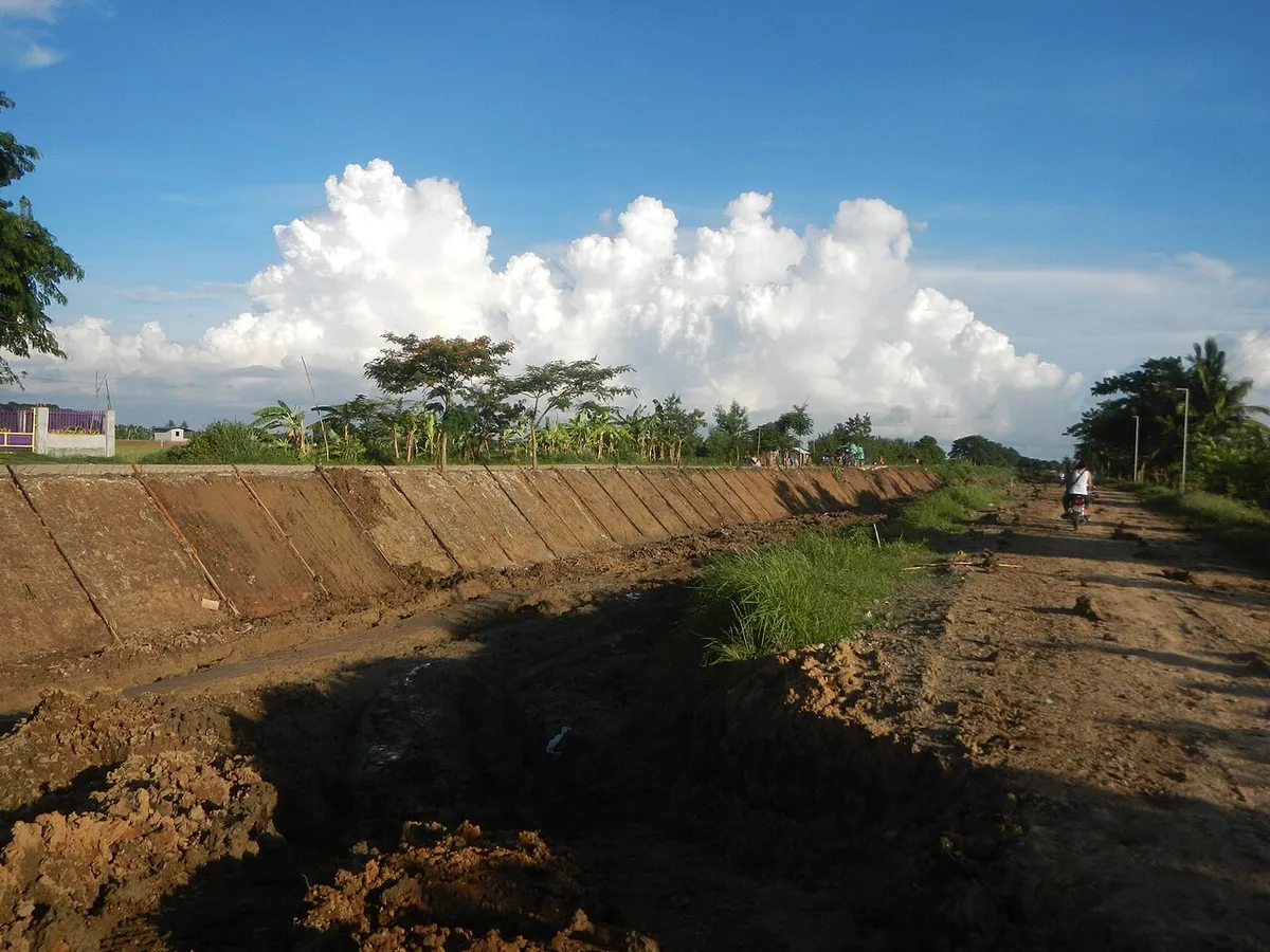 Saluran irigasi berlapis beton dalam pembangunan untuk menghentikan rembesan