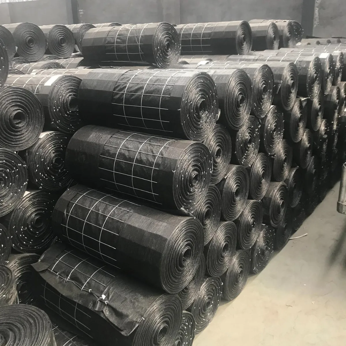 Rolls of black woven silt fence fabric with wire backing stacked in the SIGMA warehouse